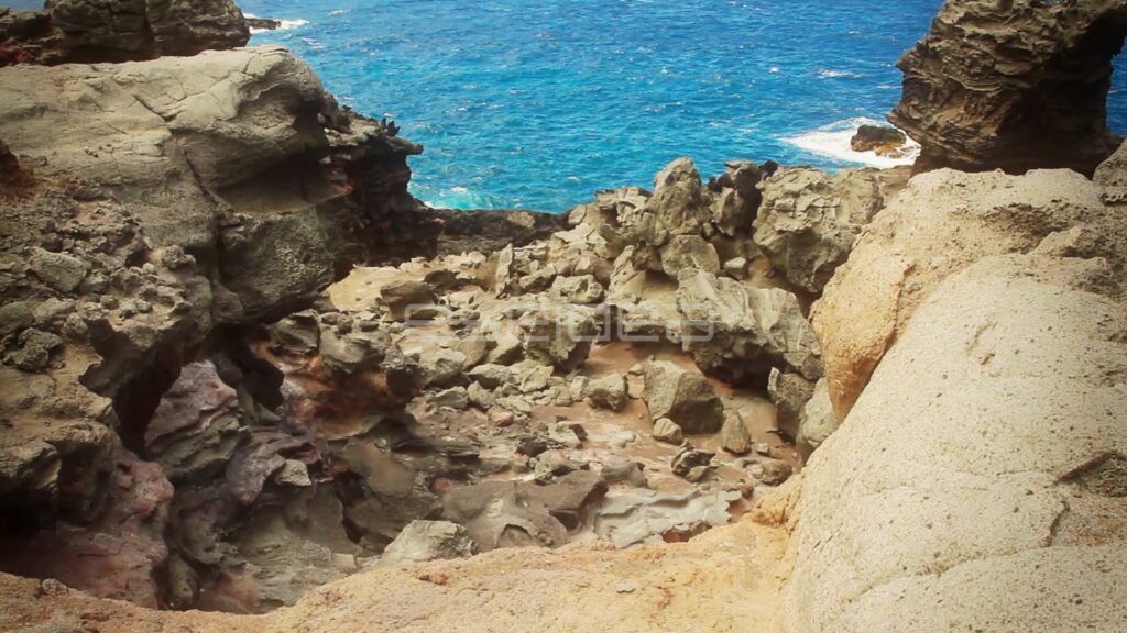 Tilt Up over Eroded Lava Rocks to Blue Ocean