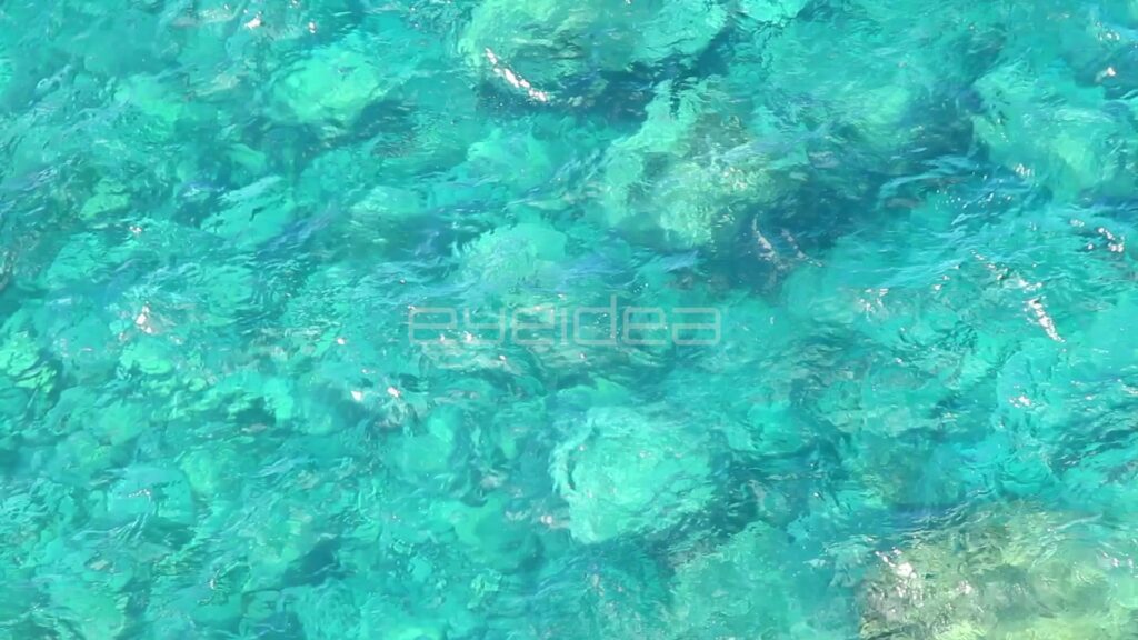 Top-Down View of Clear Turquoise Water over Rocks