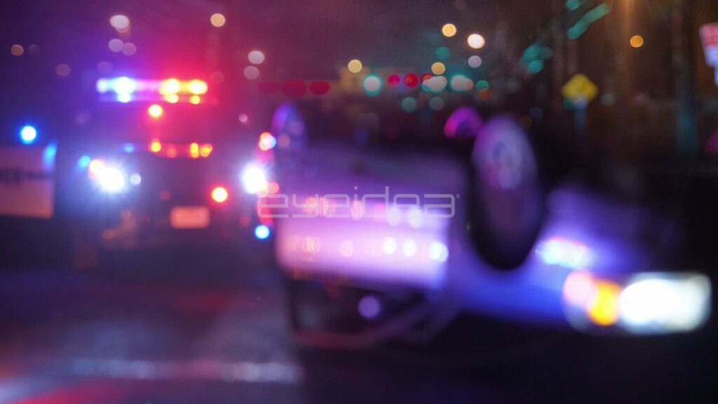Overturned Car in the Foreground of a Police Crash Scene