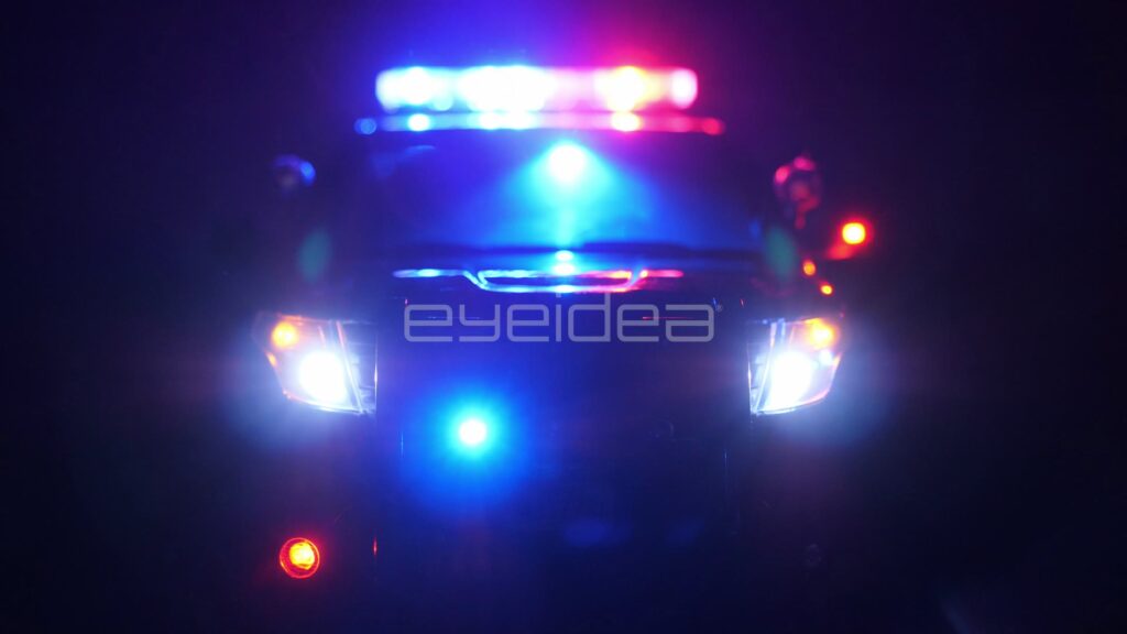 Head-On Police Cruiser with Lightbar Flashing in Darkness