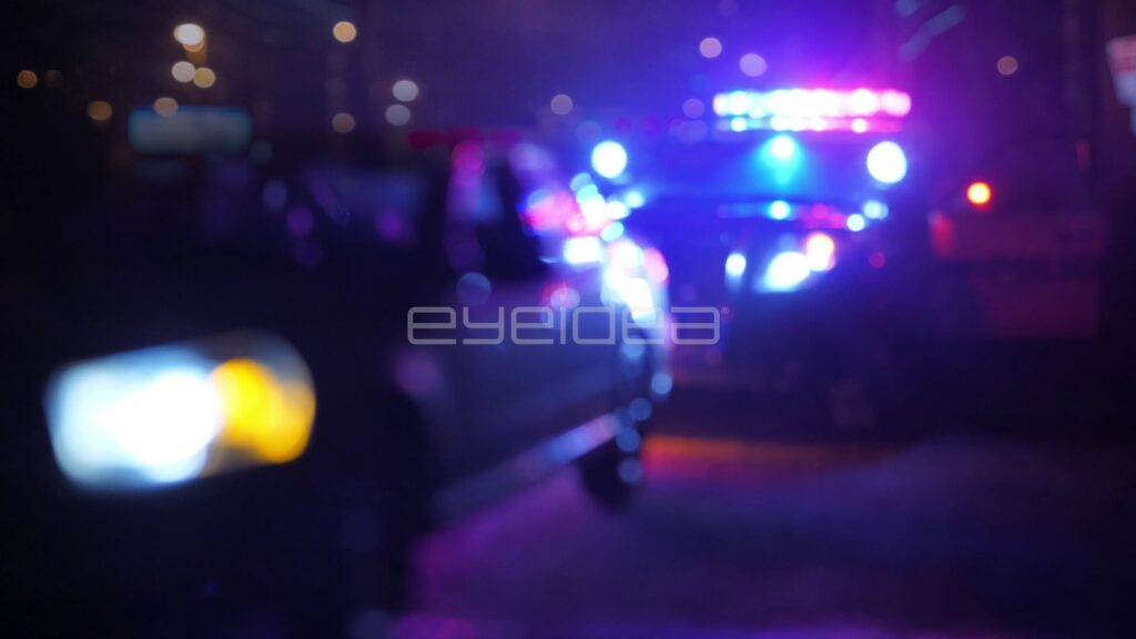 Blurred Headlight Sweeping Past a Police Stop at Night