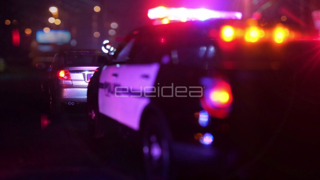 Police Cruiser Door and Red-Amber Lightbar at a Night Traffic Stop