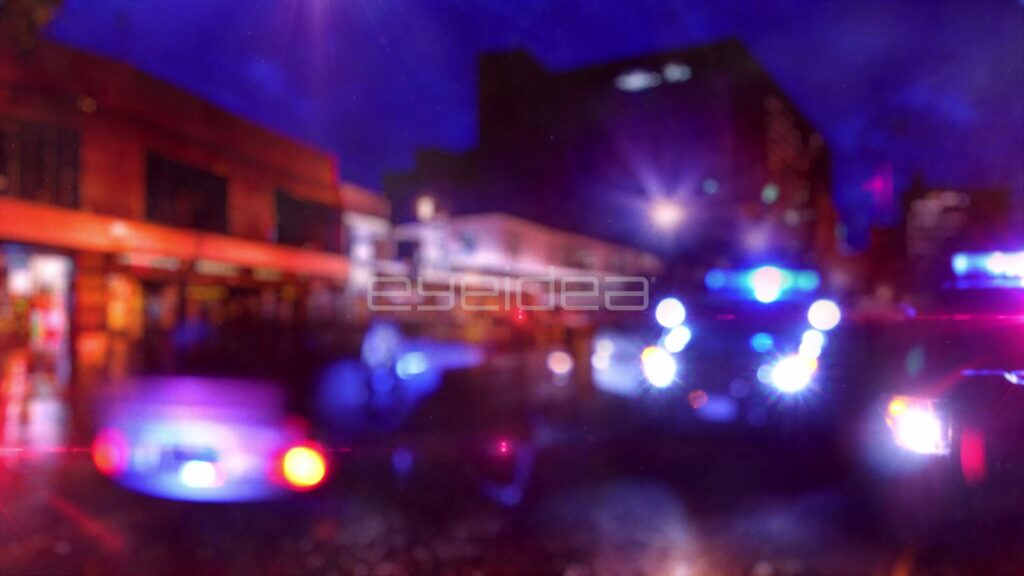 Police Lights Flashing on a Rainy Downtown Street at Night