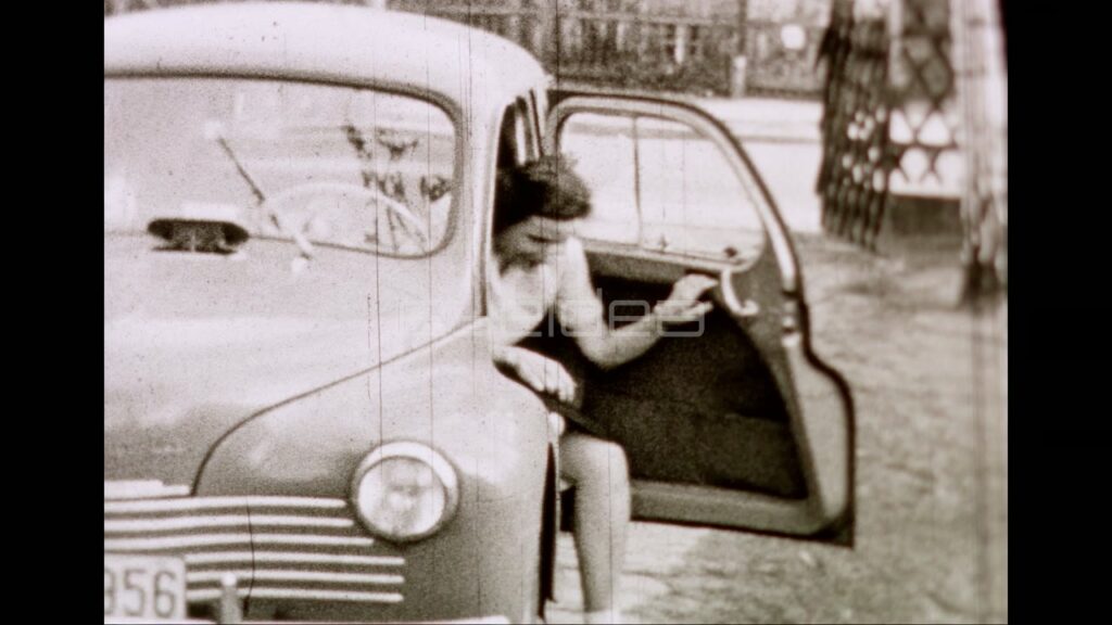 Woman Driving Vintage Car into Driveway (Archival 1950)