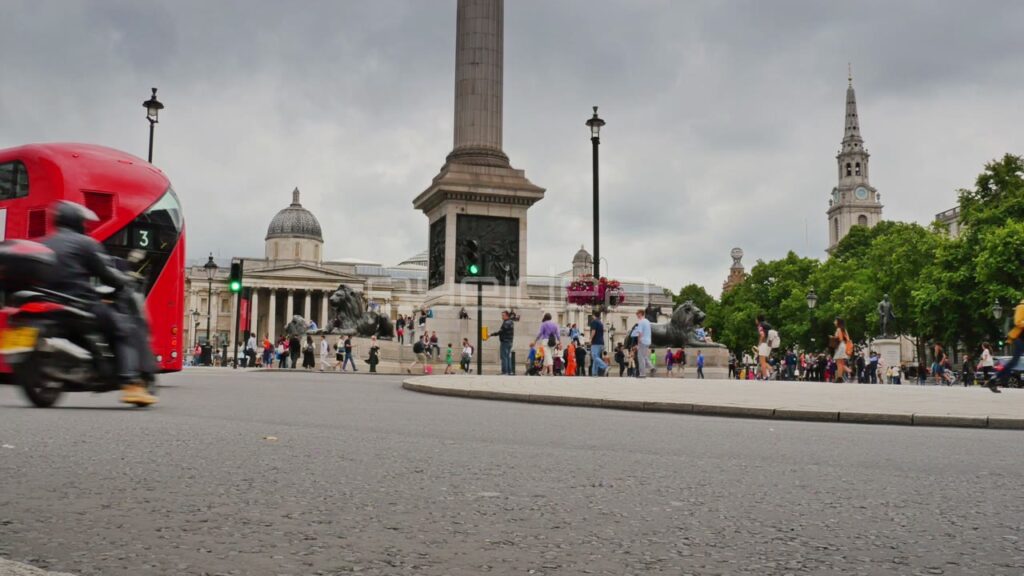 Red Bus and Taxi Pass Nelson's Column at Trafalgar Square