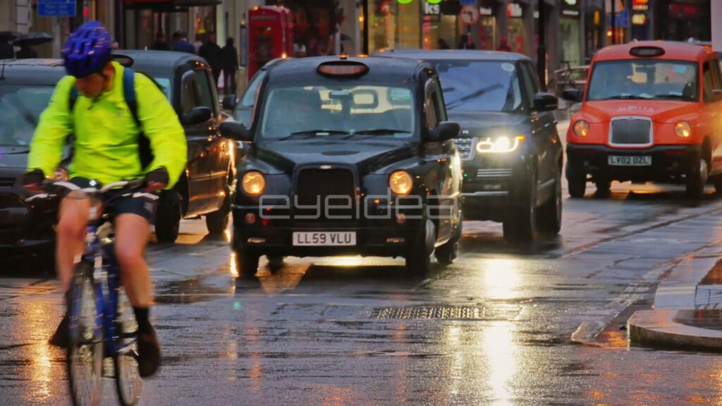 Cyclists and Taxis on Wet London Street