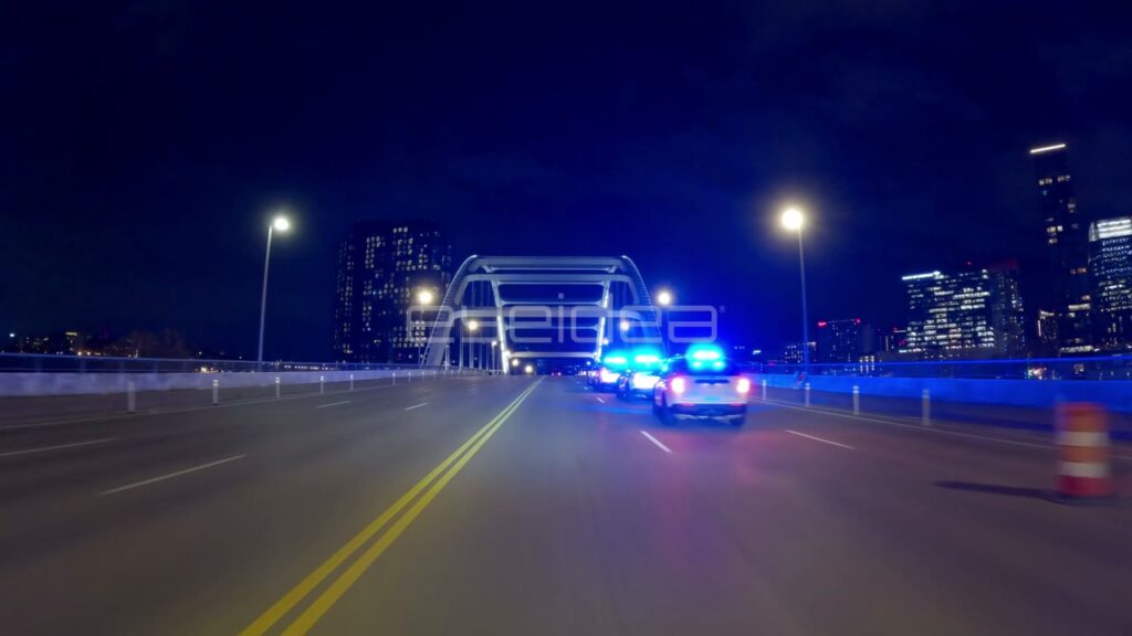 Police Cars with Flashing Blue Lights on Nashville Bridge at Night
