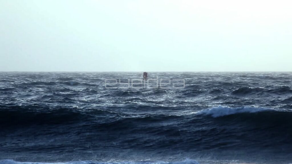 Red Buoy Bobbing in Dark Blue Rough Ocean Waves
