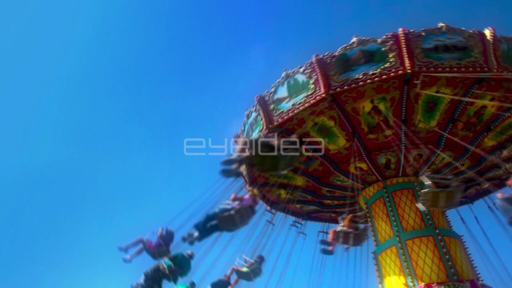 Low Angle View of Children on Colorful Carnival Swing Ride