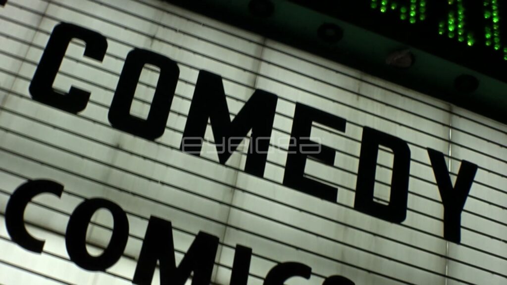 Dynamic Dutch Angle Pan of Black Comedy Marquee Sign