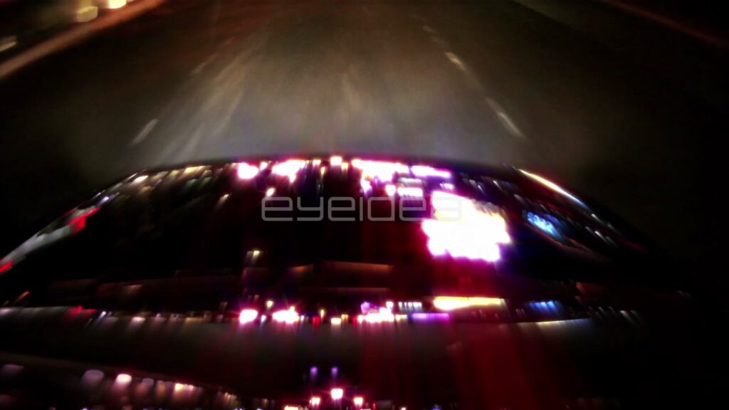 City Lights Reflecting on Car Hood at Night