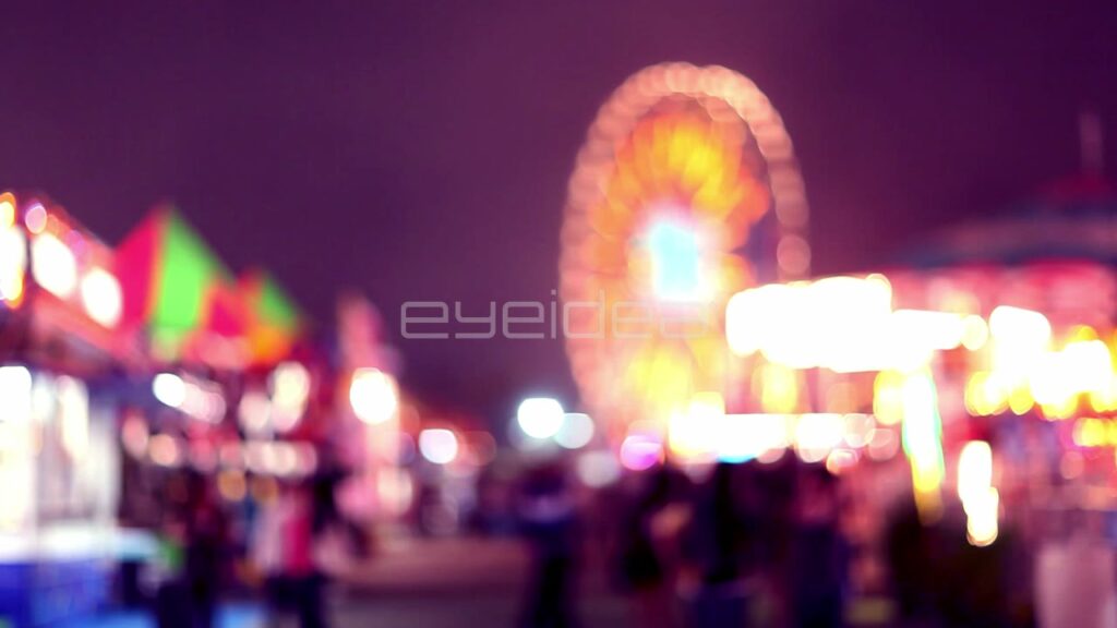 Blurred Carnival Lights and Ferris Wheel at Night