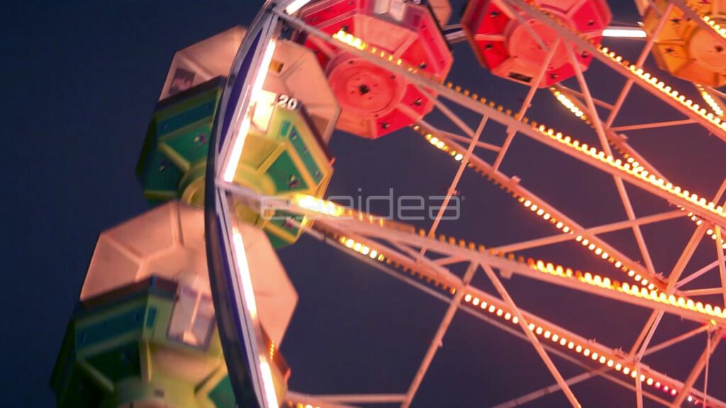 Low Angle View of Rotating Ferris Wheel at Night