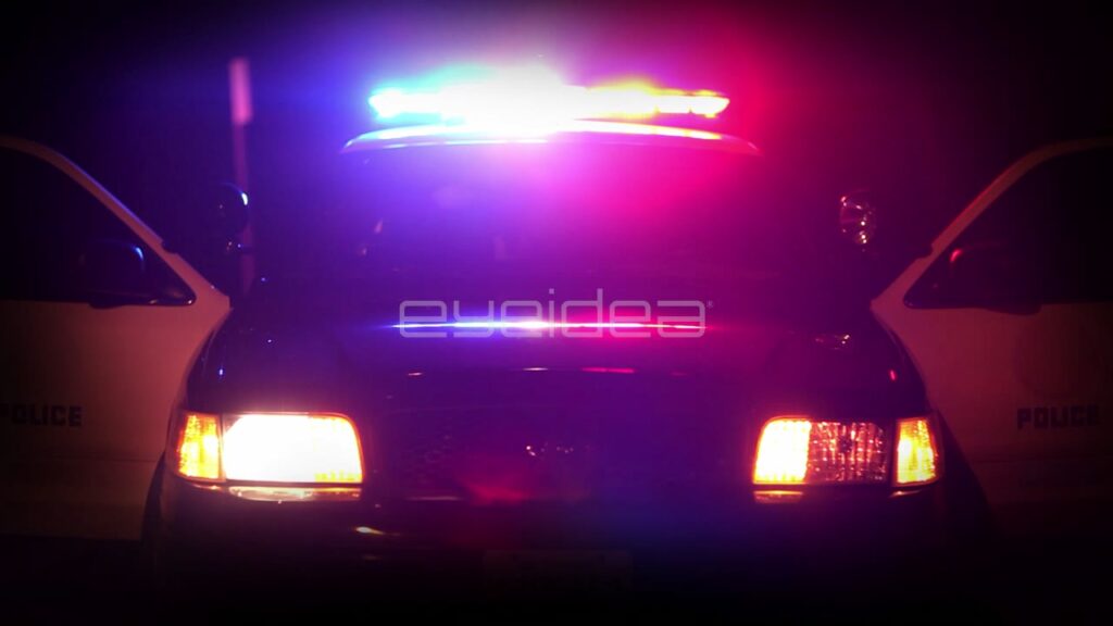 Police Car with Flashing Red and Blue Lights at Night
