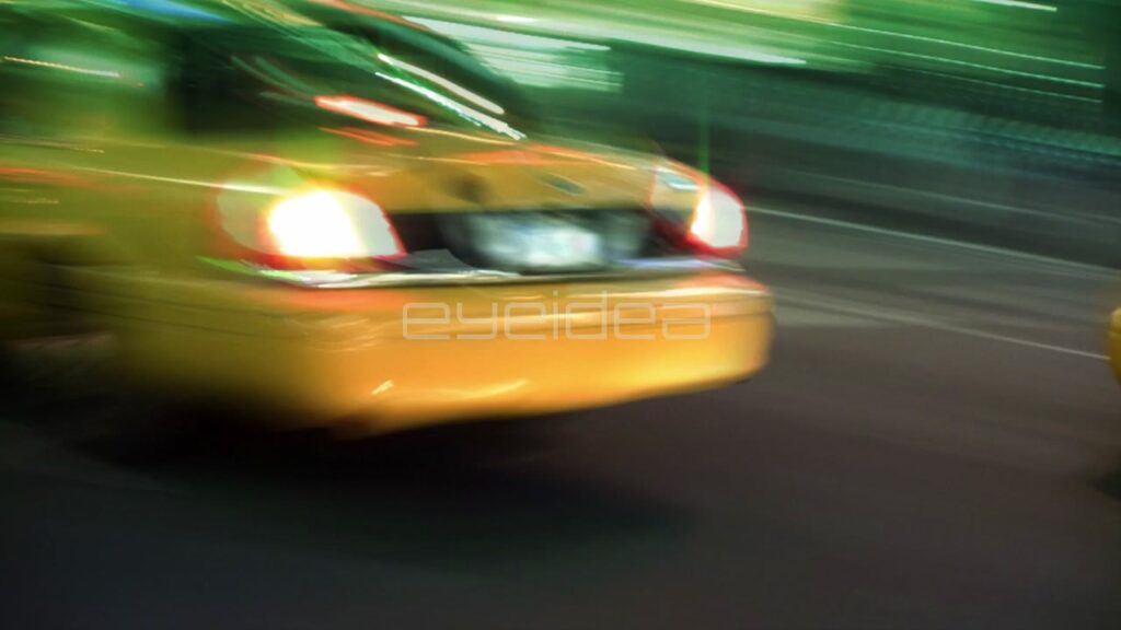 Yellow Taxis Driving Fast through Nighttime New York City Streets