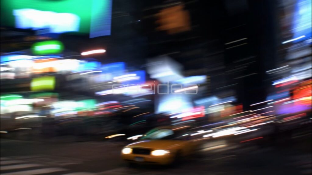 Yellow Taxi Driving through Blurred Times Square Night Lights