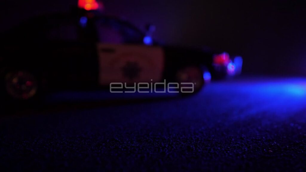 Police Car with Flashing Emergency Lights in Out of Focus Shot