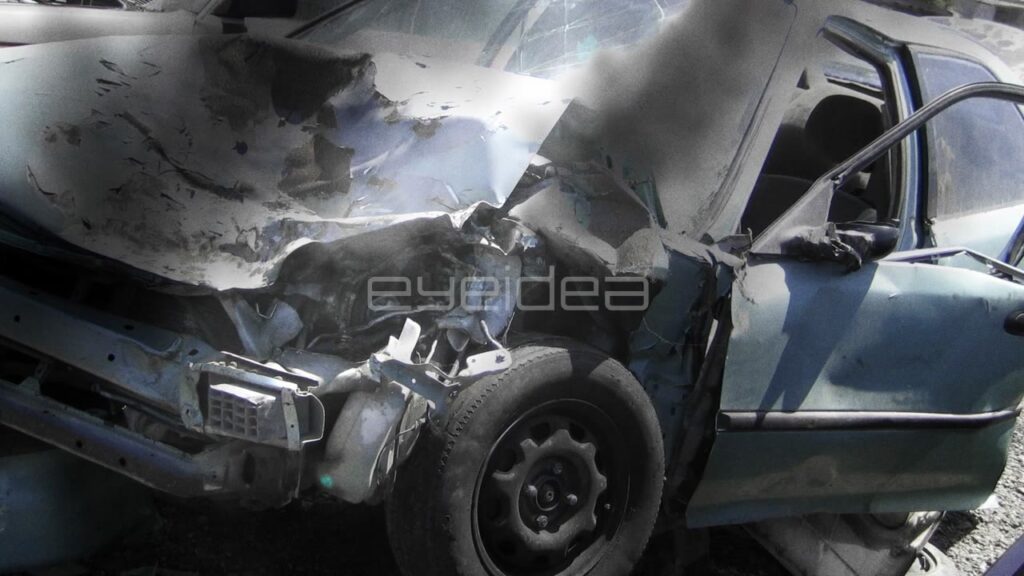 Close-Up of Smoking Wrecked Blue Car in Junkyard