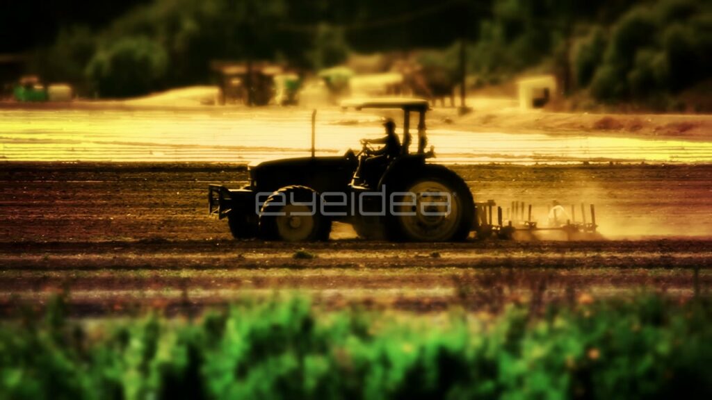 Tractor Grading Farmland in Silhouette with Golden Hour Light