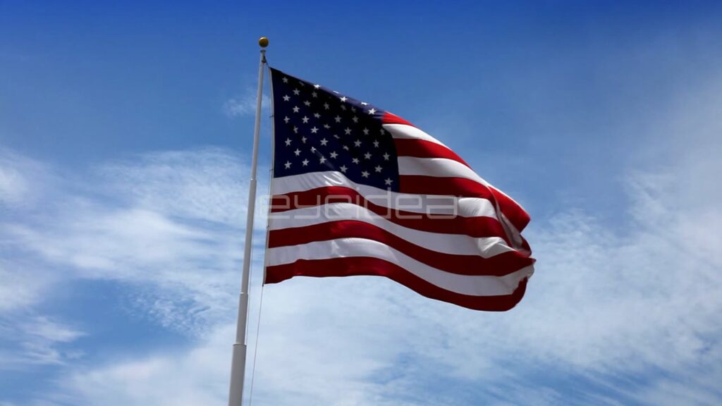 American Flag Waving against Blue Sky with White Clouds
