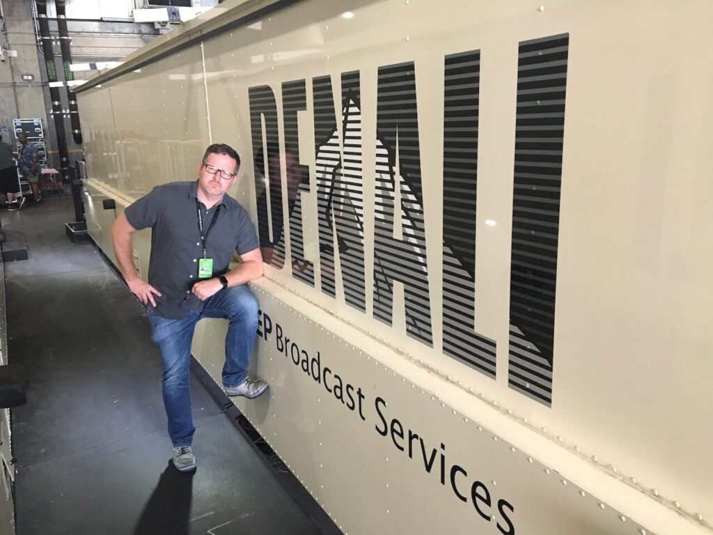 Chad J.W. Anderson beside a Denali broadcast truck